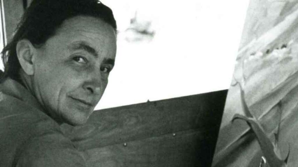 Georgia O'Keeffe junto a un lienzo.