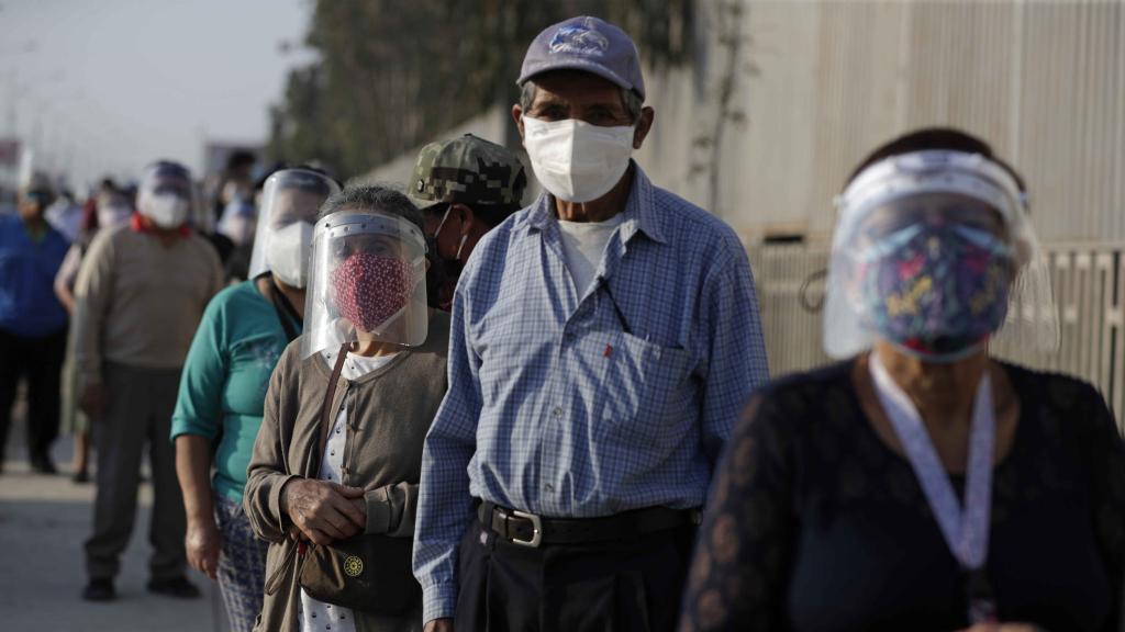 Varios peruanos esperan para acceder a un centro de votación en Lima.