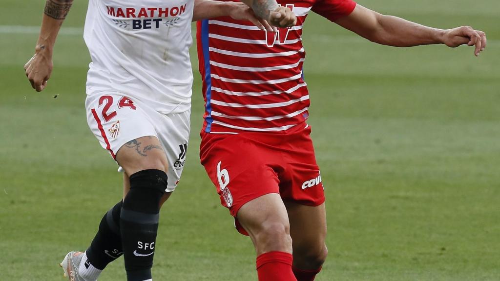 El 'Papu' Gómez se lleva el balón ante la defensa del Granada