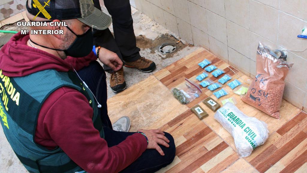 Un guardia civil con parte de las drogas que se intervinieron en uno de los registros.