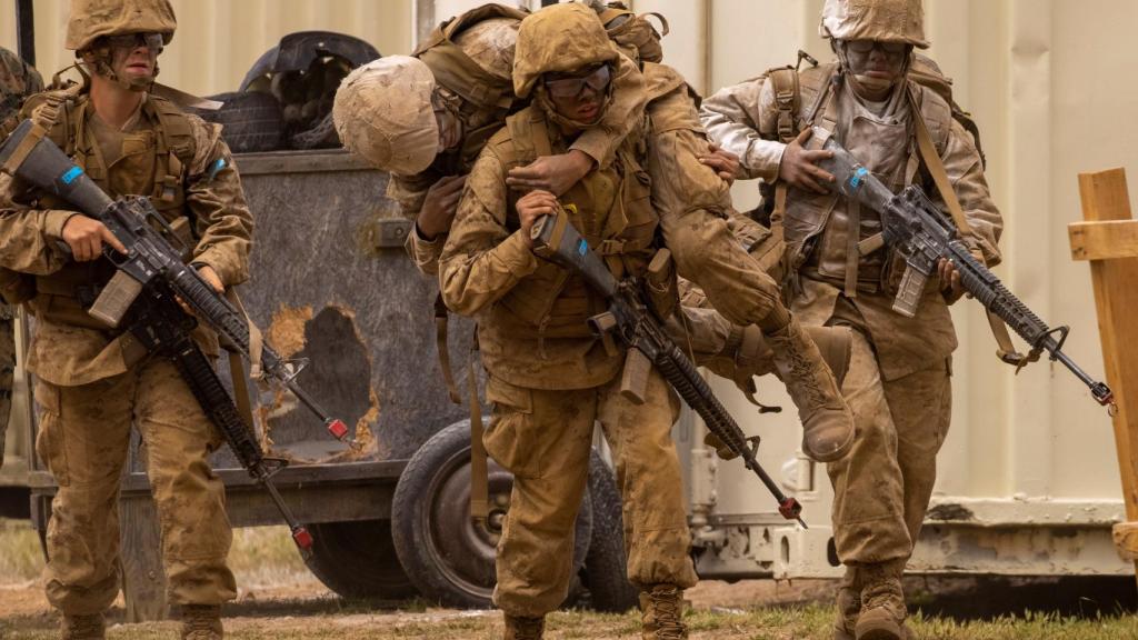 Reclutas de la Marina de Estados Unidos sostienen a sus compañeros durante la prueba del crisol.