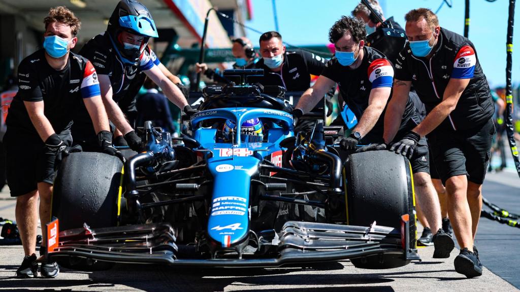 Fernando Alonso ayudado por sus mecánicos en Portimao