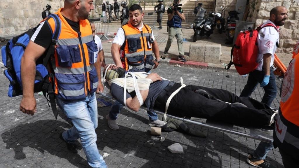 Trabajadores médicos evacuan a un hombre herido en la Puerta de los Leones.
