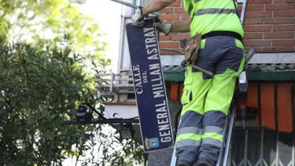Momento en el que un trabajador municipal retira la placa de la calle en honor al general Millán-Astray.