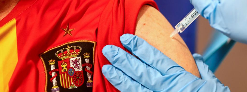 Un hombre con la camiseta de la Selección recibe la vacuna de AstraZeneca.
