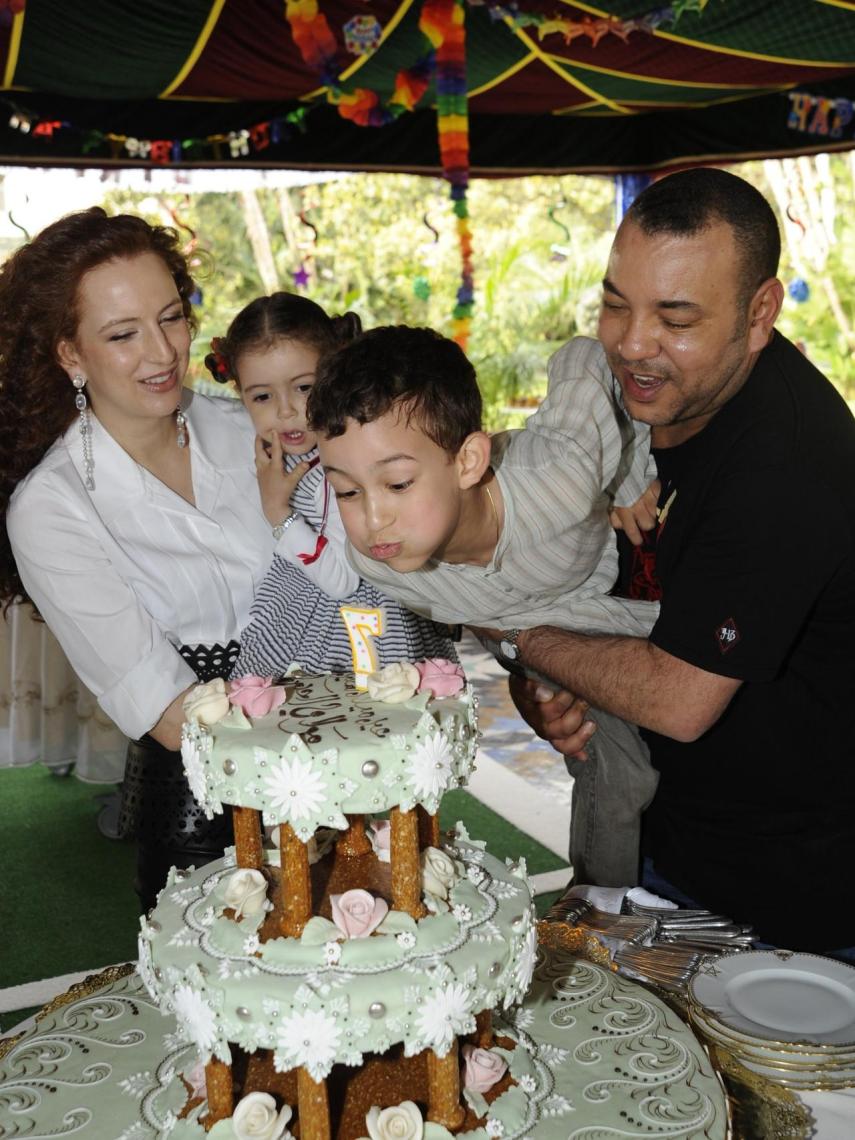 El rey Mohamed VI coge en brazos a su hijo, el príncipe Moulay Hassan, que sopla las velas por su séptimo cumpleaños ante la mirada de su madre, Lalla Salma, y su hermana, la princesa Lalla Khadija.