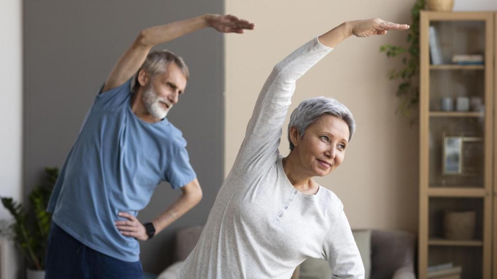 Pareja de personas mayores entrenando en casa.