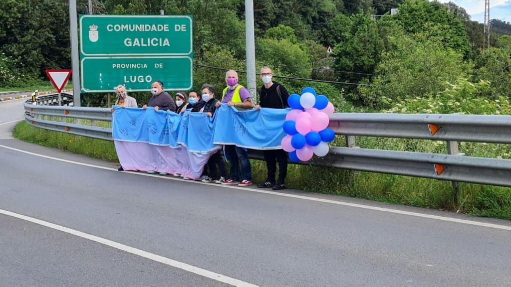 Miembros de asociaciones coruñesas reciben a bandera de manos de sus compañeras asturianas