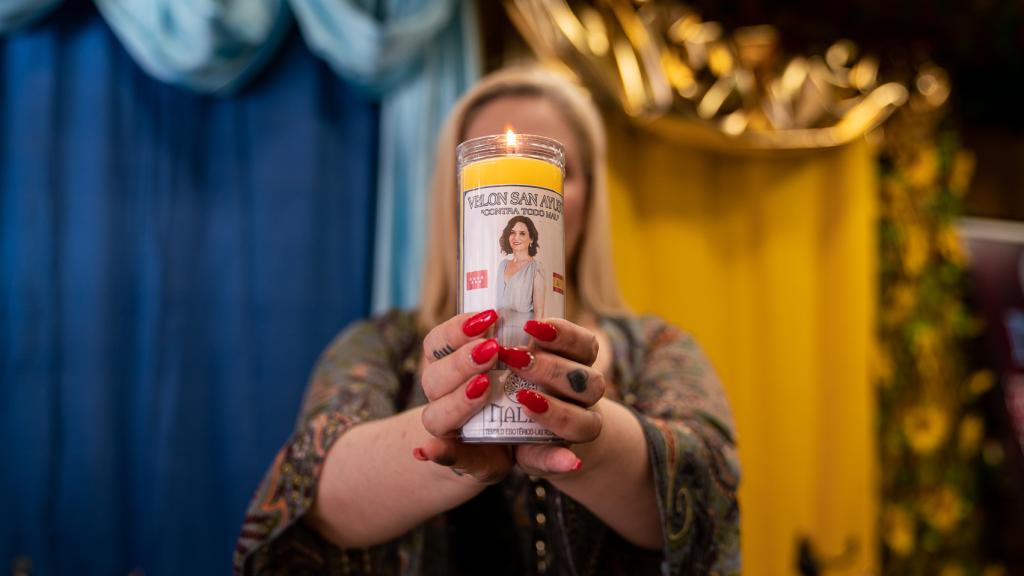 Ángela, tarotista en el Templo Esotérico Nalex, sujeta uno de los velones de 'San Ayuso' que venden.