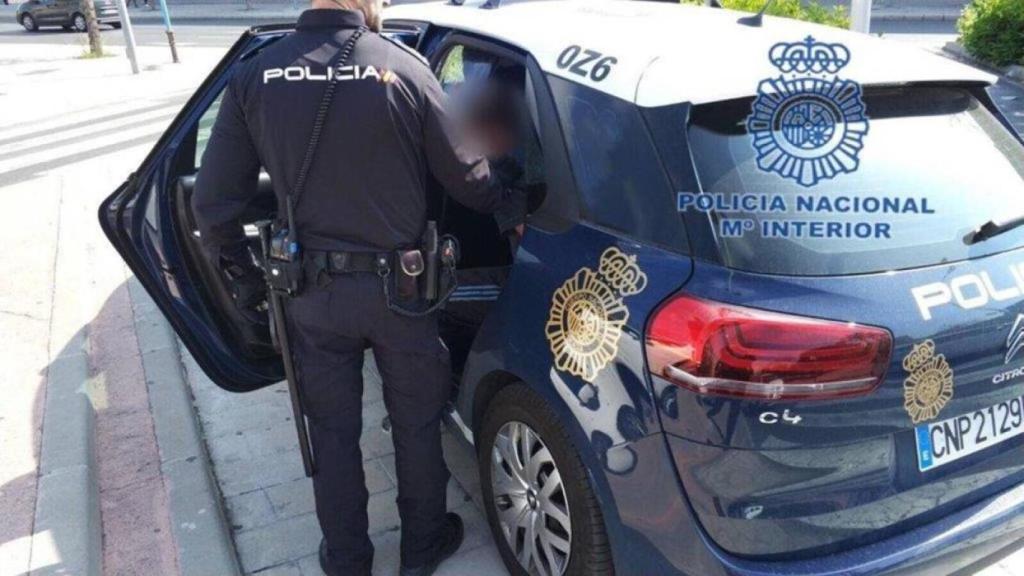 Un agente de Policía Nacional detiene a un hombre.