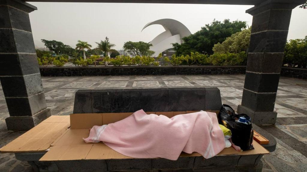 Una persona duerme en un banco en la calle, en Santa Cruz de Tenerife.