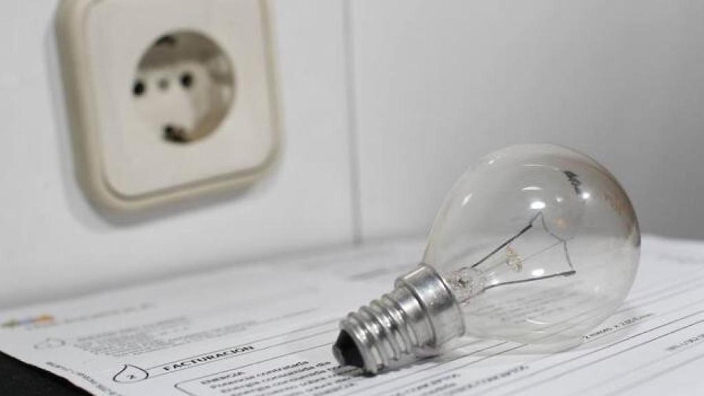 Imagen de archivo de una bombilla sobre una factura de la luz.