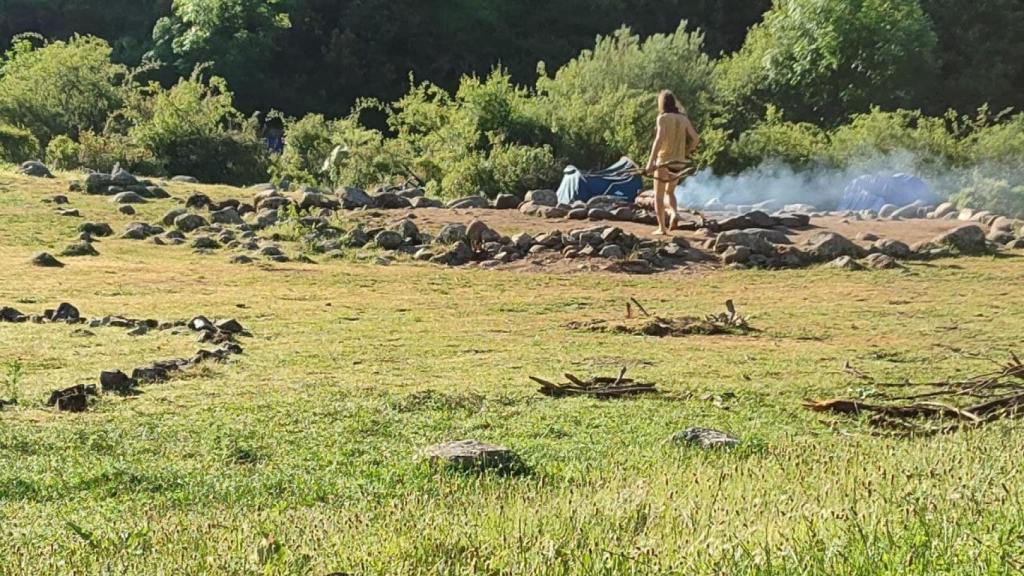 Un hermano de la Familia Arcoíris mantiene encendido el fuego sagrado a la mañana siguiente.