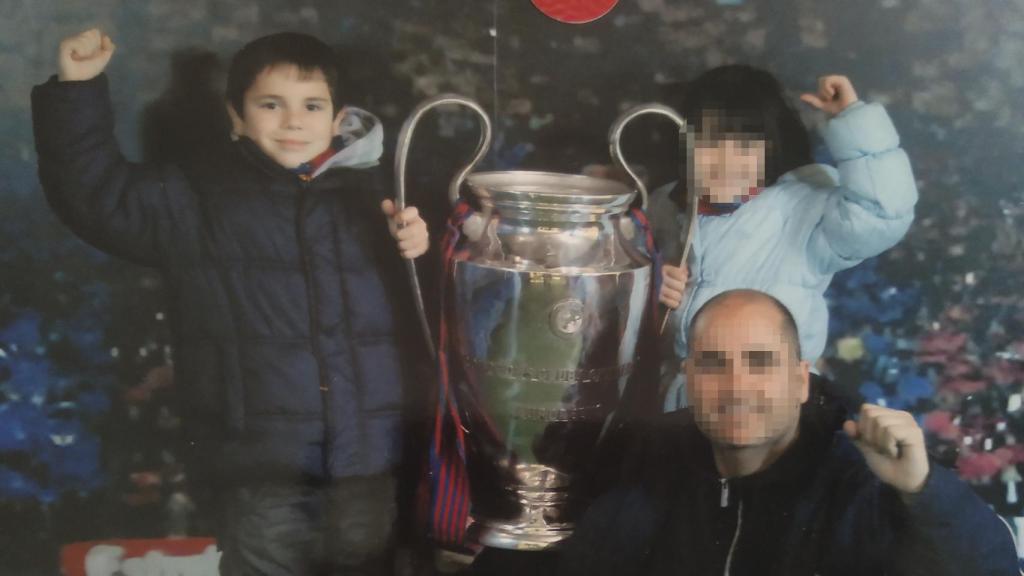Fernando con el puño en el alto mientras sujeta una Copa de Europa ganada por el FC Barcelona.