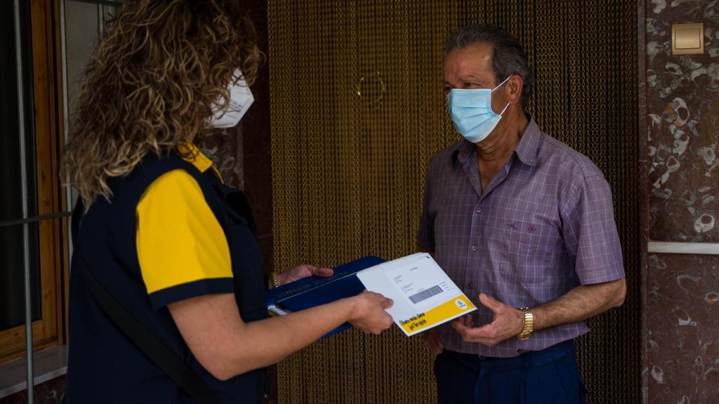 María del Mar le entrega a Salvador el dinero en efectivo que ha pedido a través de la app de su banco.