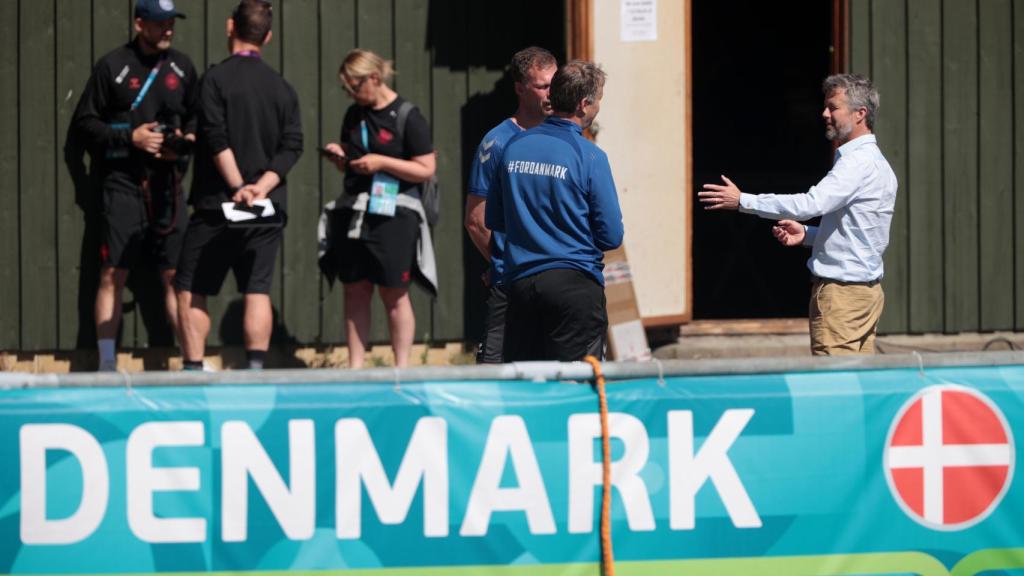 Kasper Hjulmand y varios miembros de Dinamarca conversan antes de un entrenamiento