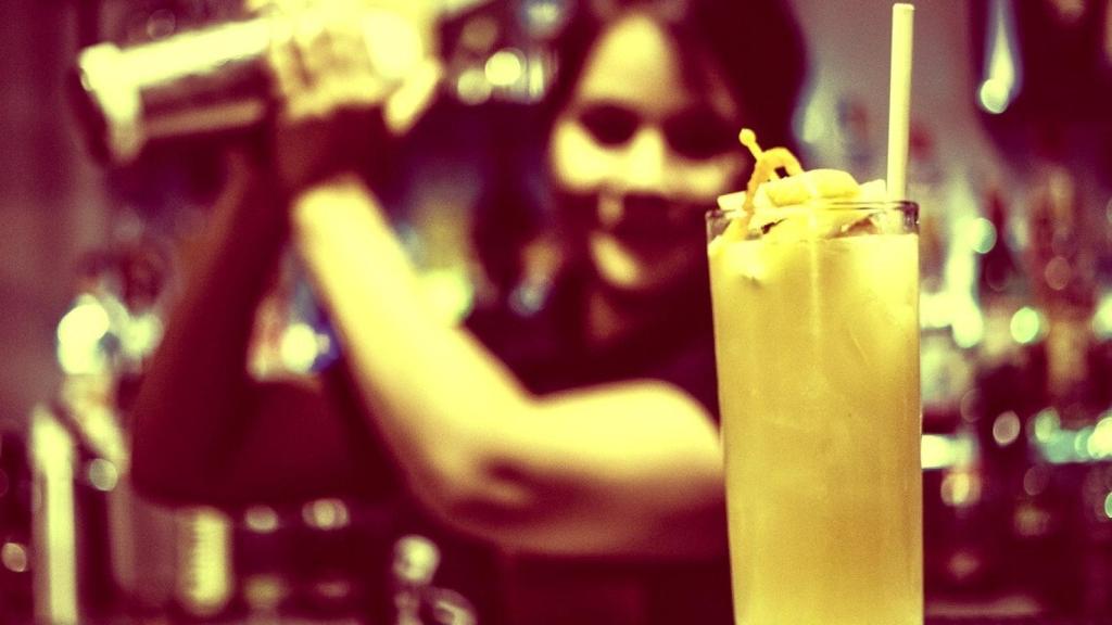 Una mujer barista prepara un combinado.