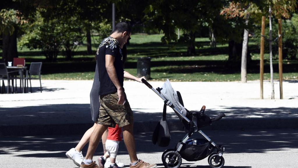 Una pareja y su bebé empujan el carrito del mismo en una imagen de archivo