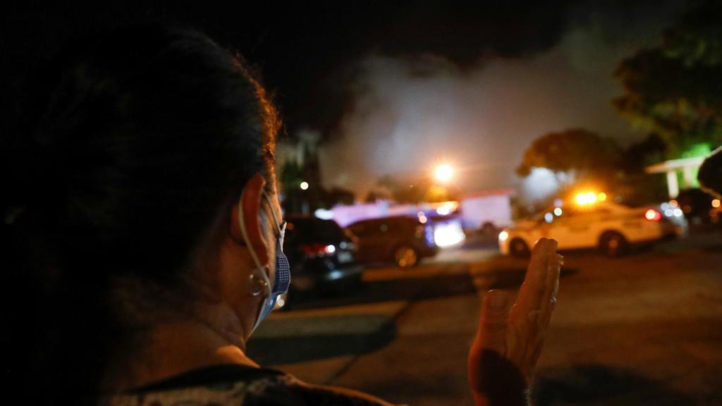 Una persona en el entorno del edificio en el momento de la demolición.