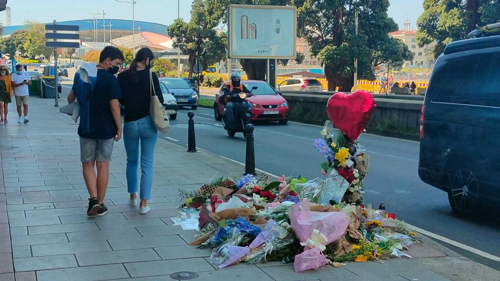 Una pareja observa las coronas de flores en el lugar de la paliza a Samuel, en A Coruña.