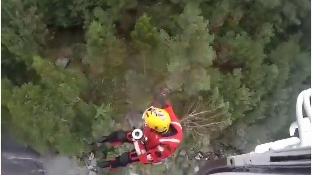 Un operario de rescate acude a por la joven en el entorno del río Pedras.