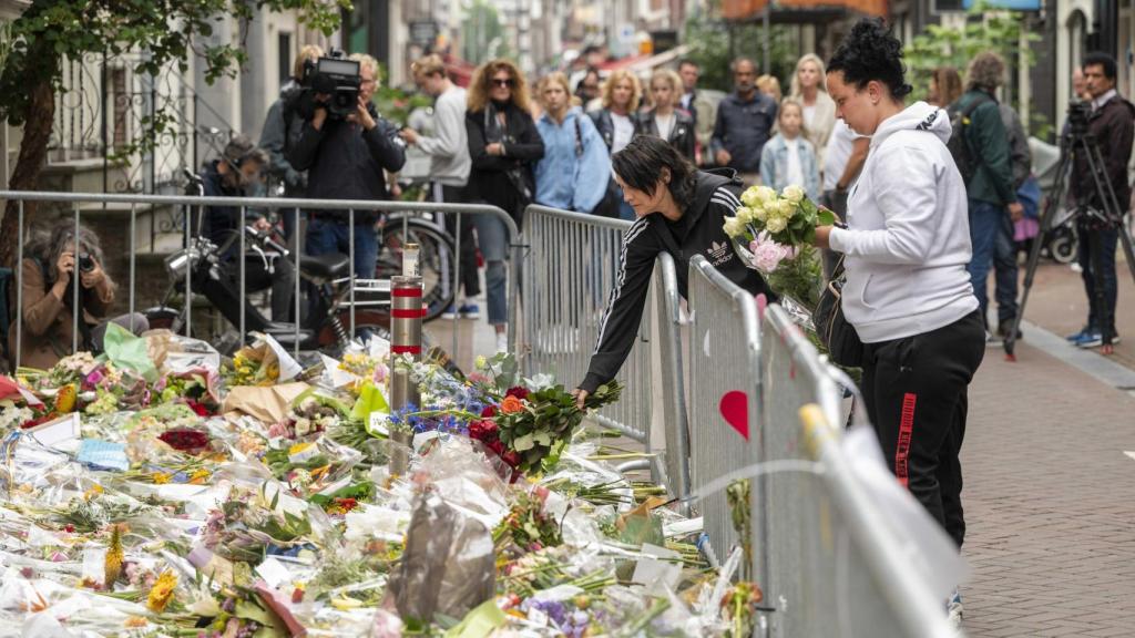 Personas dejando flores en honor al periodista fallecido.