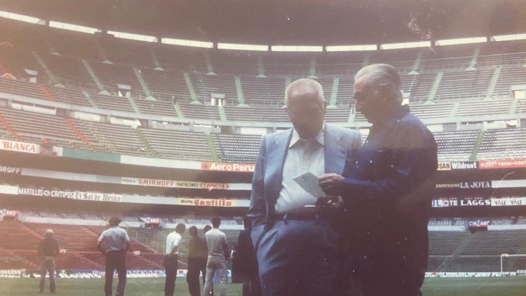 Rico Pérez y Manolo Calvo en el Azteca, mientras los jugadores miran impresionados el estadio.