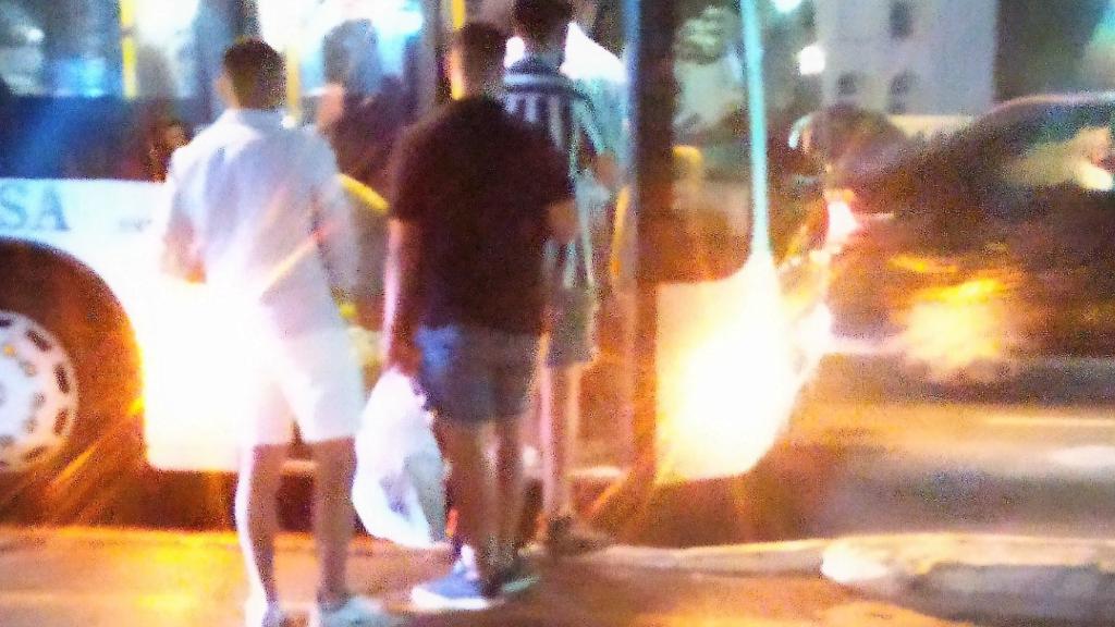 Un grupo de jóvenes se sube al autobús con bolsas con botellas para hacer botellón en la playa.