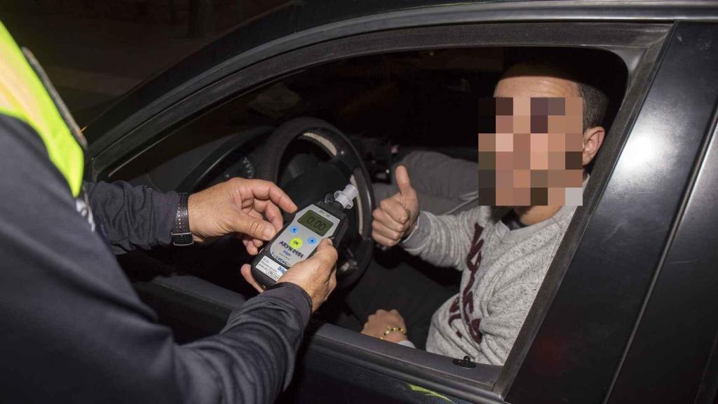 Un agente de la Guardia Civil controla la tasa de alcoholemia de un conductor.