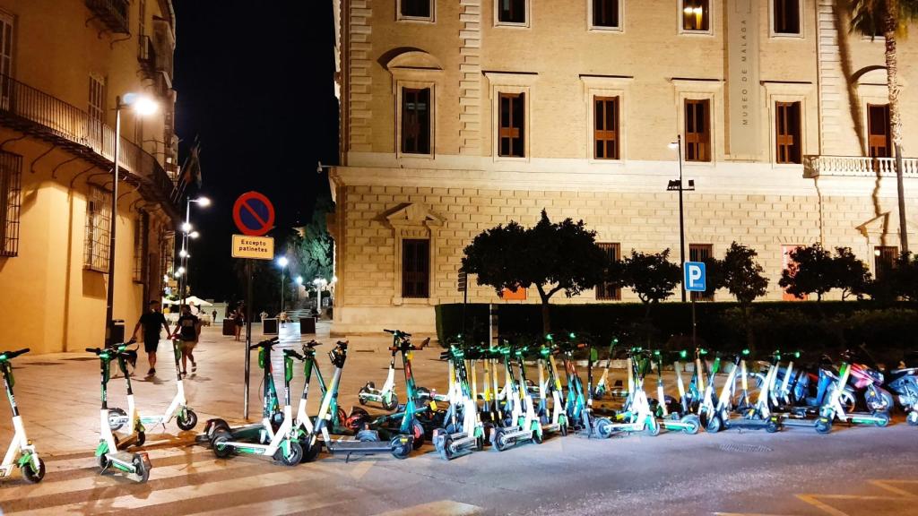 Imagen de archivo de varios patinetes de Lime aparcados junto al Palacio de la Aduana, en Málaga.
