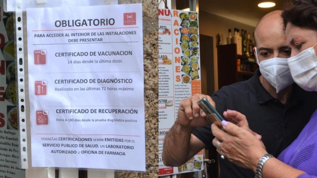 Un camarero comprueba el certificado Covid en un restaurante de Santiago.