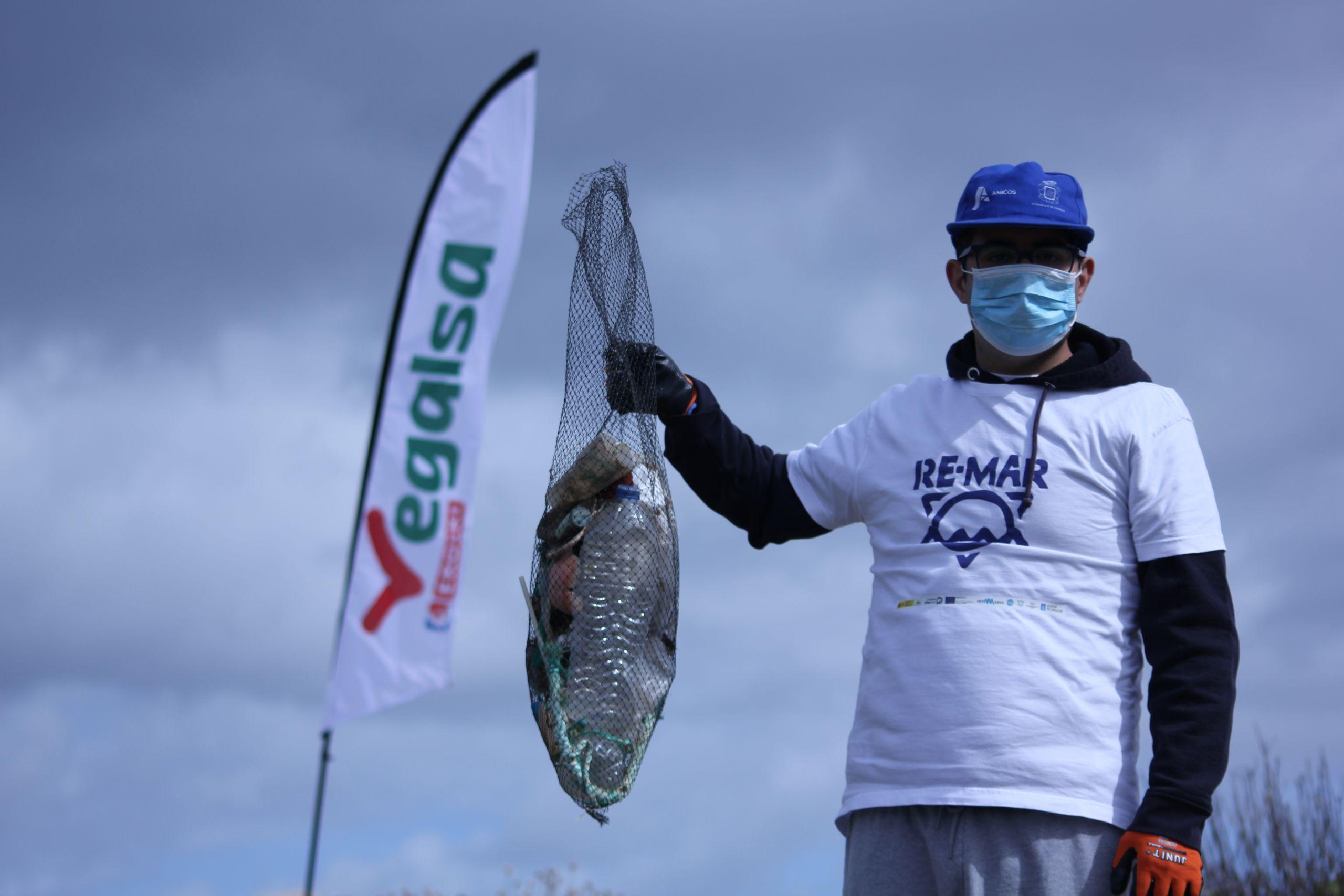 Voluntario recoge basura en una playa