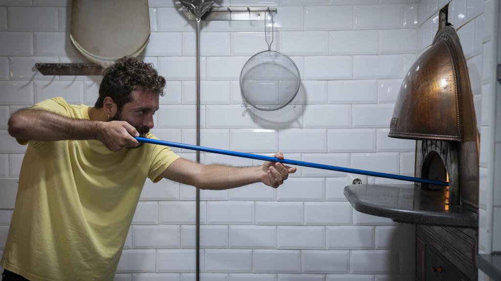 Vittorio Figurato, manipulando el horno donde se hacen sus pizzas artesanales.