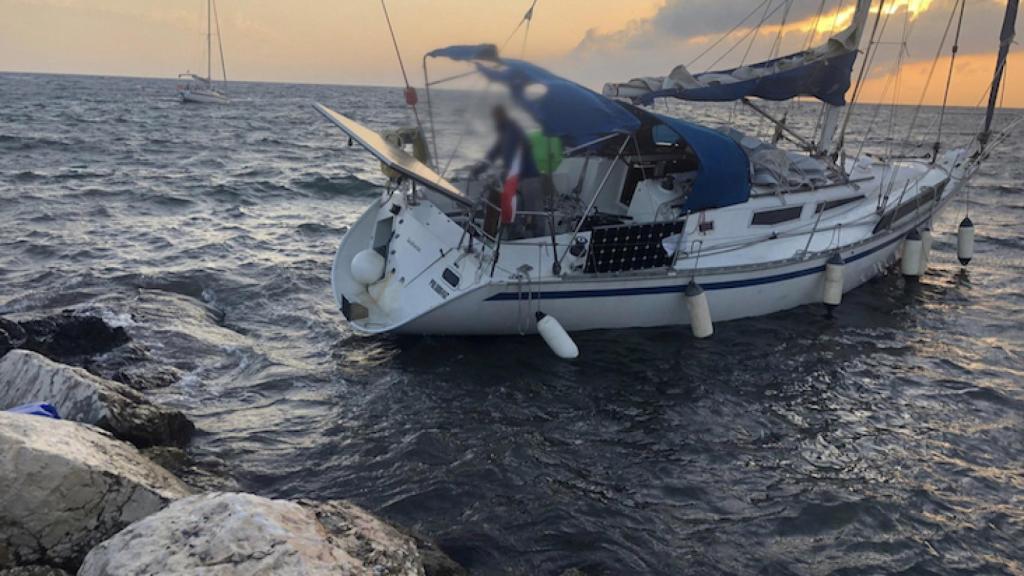 Velero encallado en las rocas de la escollera de la parte trasera de los acantilados en Tabarca.