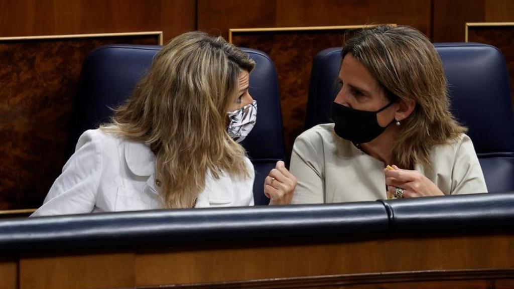 Yolanda Díaz y Teresa Ribera, conversando durante un pleno parlamentario.