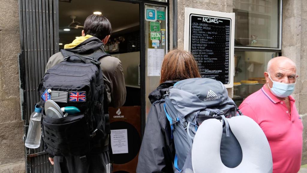 Dos peregrinos frente a un local de hostelería.