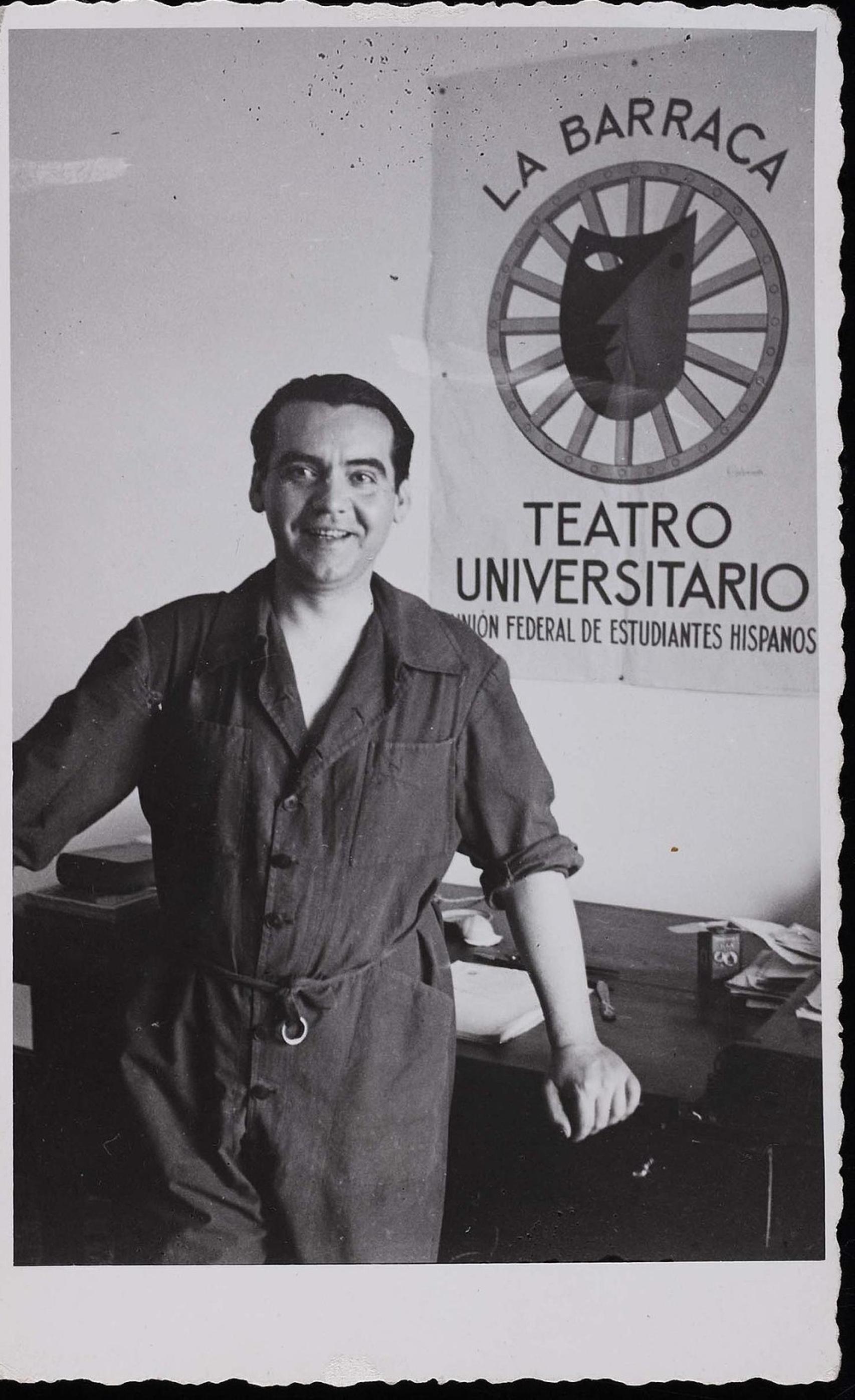 Lorca en 1932 junto con un cartel de La Barraca.