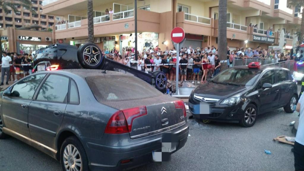 El coche implicado en el accidente en el que ha muerto un ciclista en el paseo marítimo de Fuengirola, volcado en plena vía ante la atenta mirada de ciudadanos