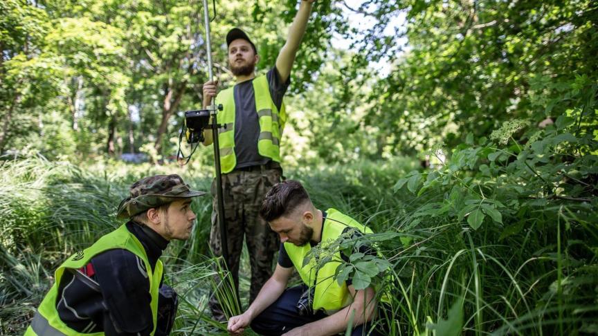 Kobiałka sobre el terreno recogiendo restos de cenizas humanas.