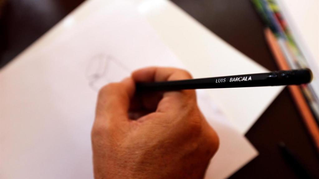 Detalle de Luis Barcala dibujando en una libreta.