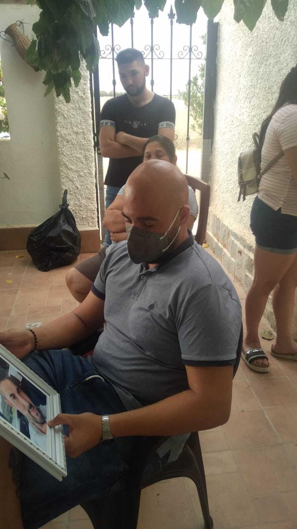 Adán contempla con tristeza el retrato de su difunto hermano, Juanmi.