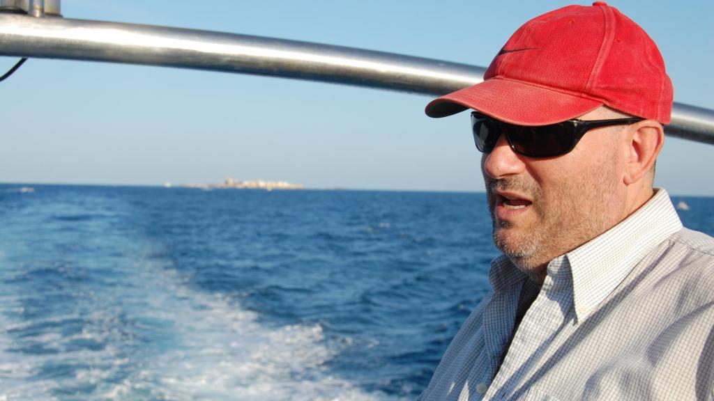 Pérez Burgos, en una de las travesías a Tabarca, al fondo, donde gestiona el museo.