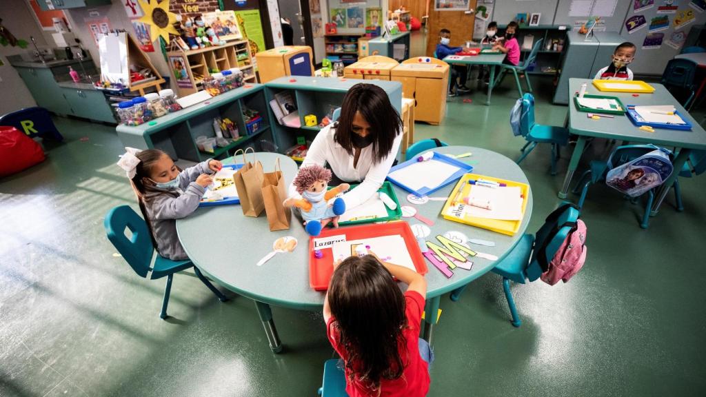 Una profesora da clase en Infantil.