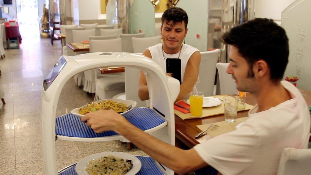 Unos comensales se sirven tras ser atendidos por el robot Cacahuete.
