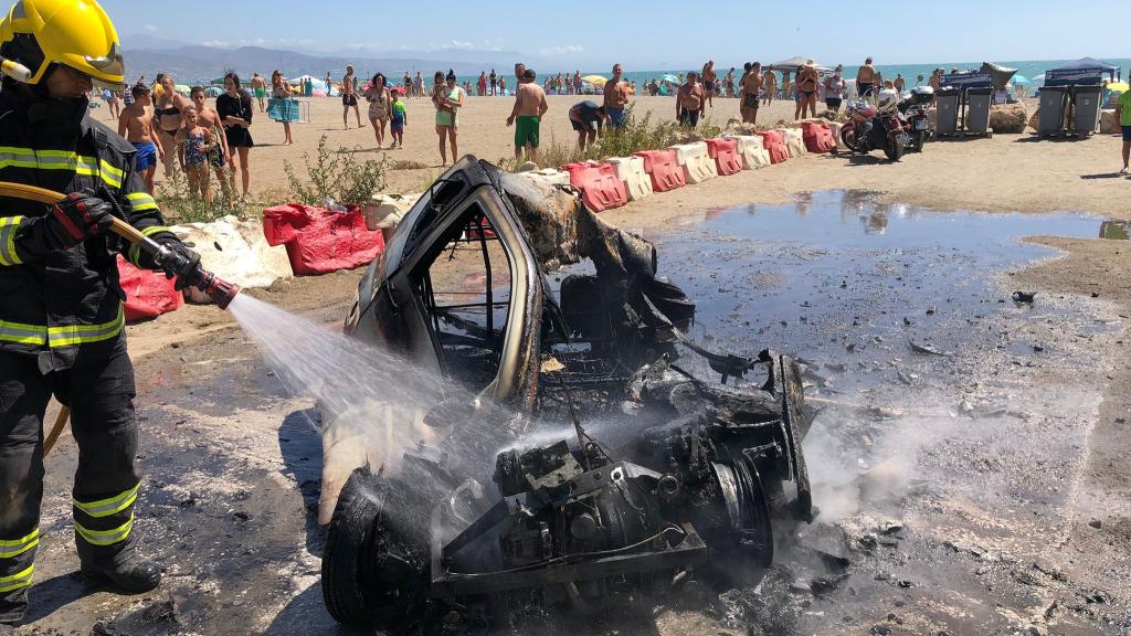 Un bombero apaga el fuego del coche en Sacaba.
