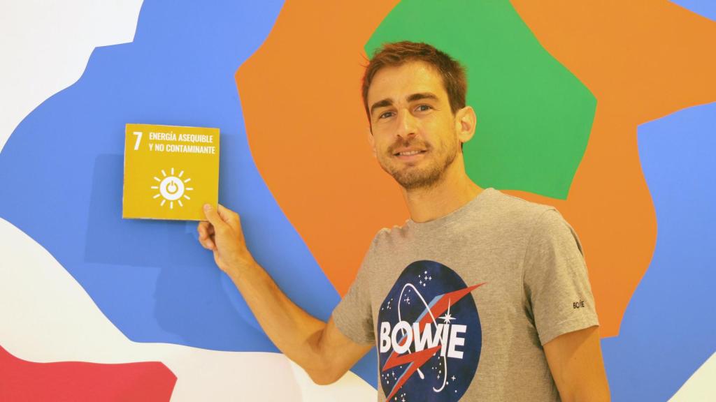Gonzalo Murillo posa junto al cartel del ODS 7 (energía asequible y no contaminante).