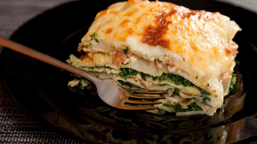 Una lasaña de espinacas con queso gratinado.