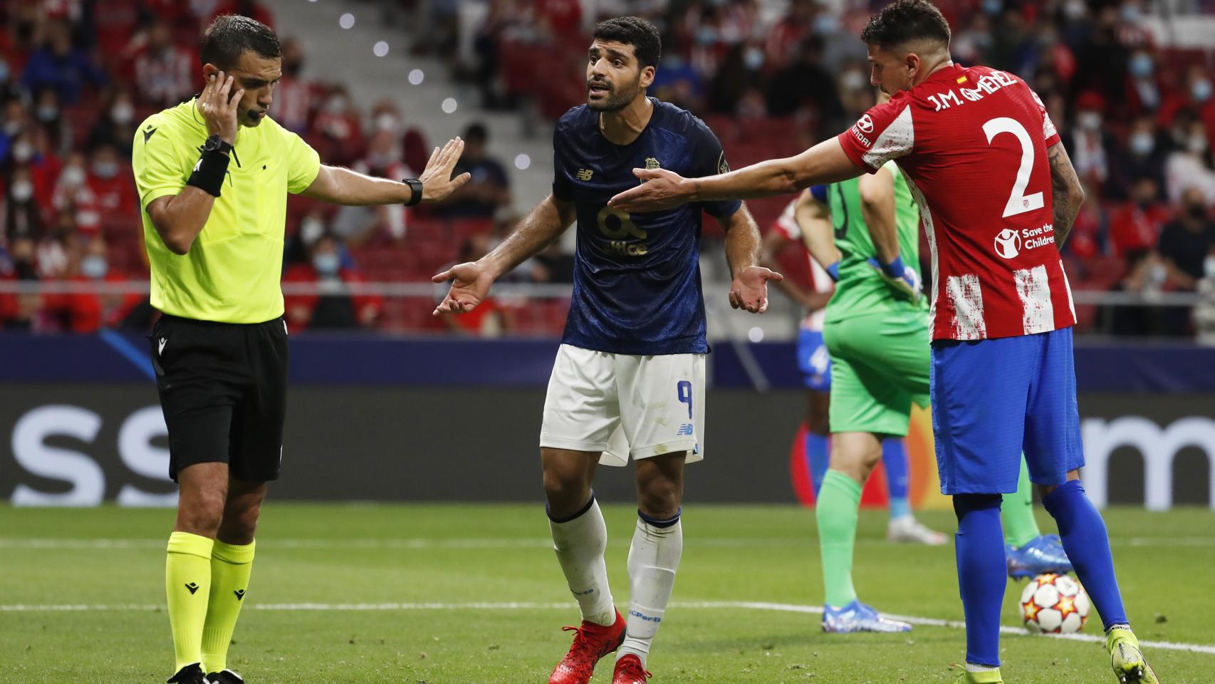 El árbitro, Taremi y Giménez, durante el Atlético de Madrid - Oporto