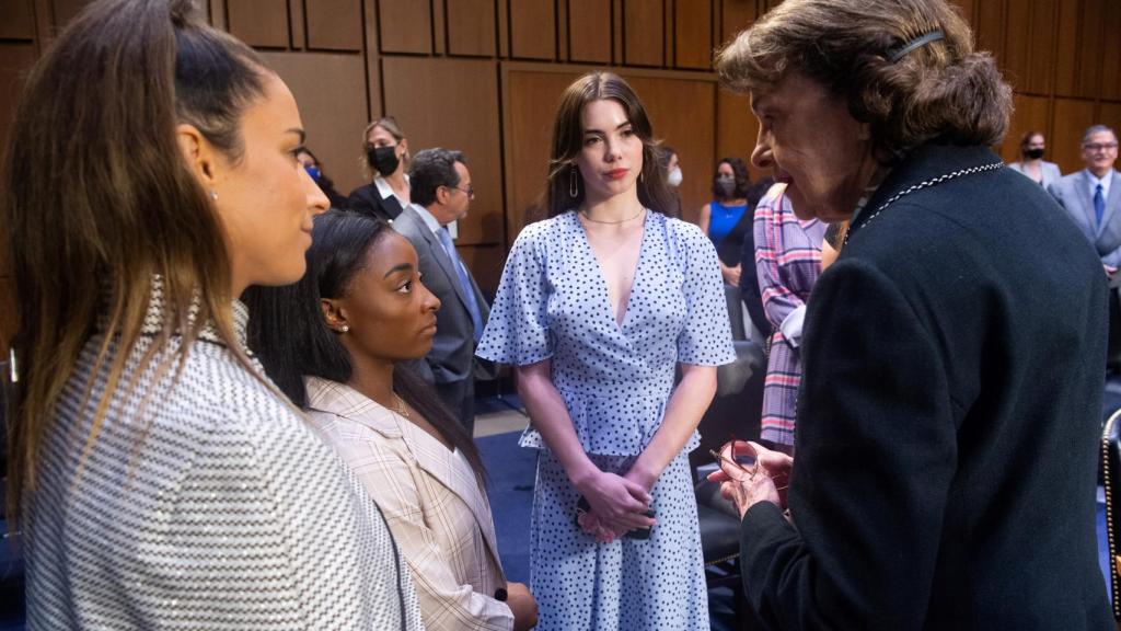 La senadora  Dianne Feinstei hablando con Aly Raisman, Simone Biles y McKayla Maroney
