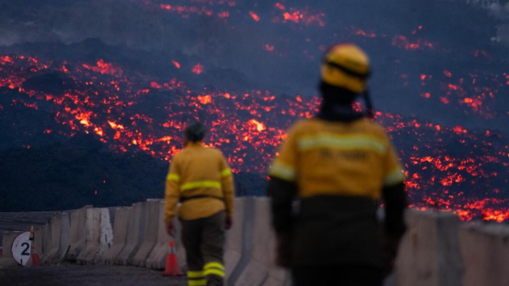 Dos bomberos, frente a las lenguas de lava.